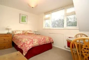 Well-lit double bed, bedside dresser and table with two chairs