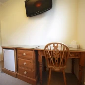 View of mini fridge, desk and TV
